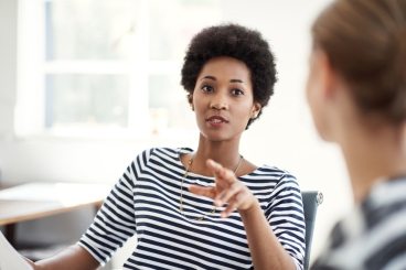 Two professionals having a discussion in an office.